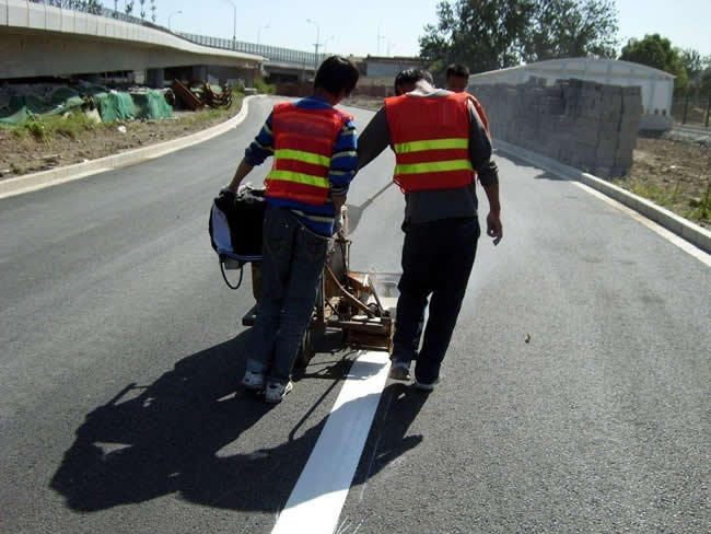 青岛划线的工人师傅们正在施画道路的标志标线